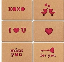 Brown kraft cards with red heart cutouts featuring XOXO and I Love U text patterns