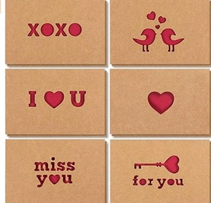 Detailed view of six kraft paper greeting cards with red hollowed-out romantic heart designs