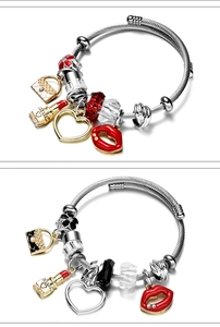 Detail of adjustable wire bangles with red and black charms including lipstick and heart
