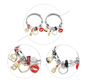Detail of adjustable steel wire bracelet with enamel heart and lipstick charms