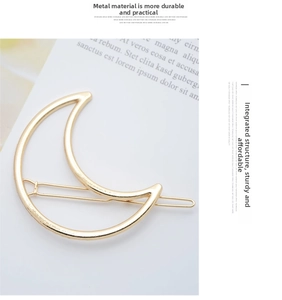 Close-up of golden metal crescent moon hair clip on minimalist white card with text
