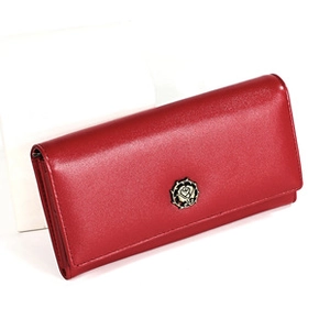 Close-up of red oil wax leather long wallet featuring a metallic rose badge detail