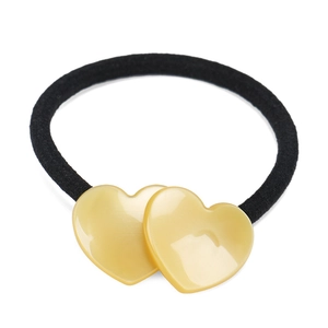 Close-up of yellow heart resin charm with black elastic band on white background