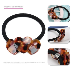 Macro detail of tortoiseshell heart hair tie with polished resin and elastic band