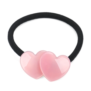 Detail shot of heart-shaped acetate charms on a black elastic hair tie with glossy finish