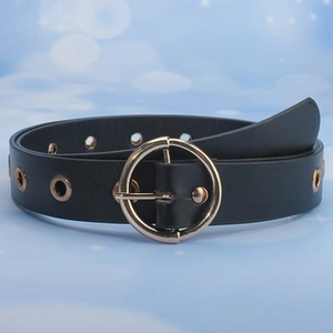 Detail of black leather waist belt featuring round gold buckle and metal eyelet studs