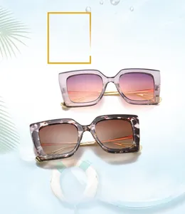 Detail of square oversized sunglasses with gold metal temples and gradient lenses