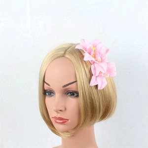 Detail view of the pink orchid flower hair comb showing fabric texture and yellow stamens