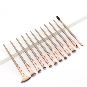 Close-up of 12 makeup brushes with rose gold ferrules and gradient bristles