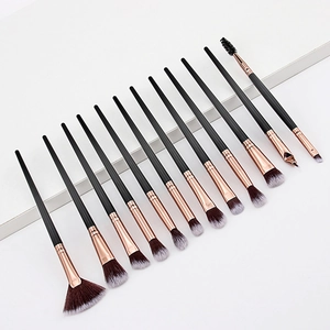 Detailed close-up of 12 champagne gold makeup brushes set with black wooden handles