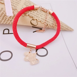 Detail of red woven bracelet with golden mouse pendant featuring Fu character and bow