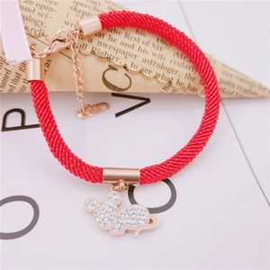 Detail of red braided rope bracelet with rose gold mouse charm and white crystals