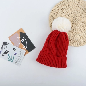 Gros plan du bonnet de Noël en tricot rouge avec pompon blanc sur un fond décoratif