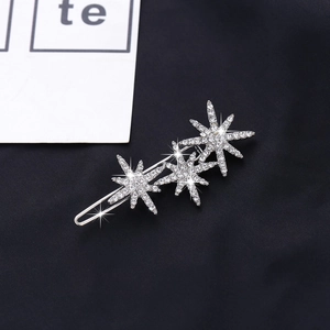 Close-up of sparkling snowflake hair clip with shiny rhinestones on black background