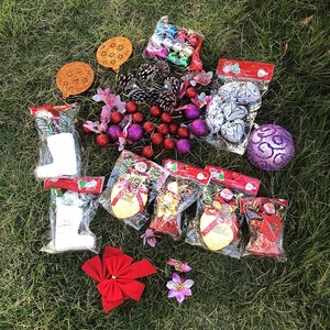Flat lay of Christmas ornaments set with baubles, pine cones and bows on green grass