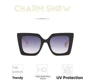 Detail of oversized black square sunglasses featuring gradient lenses and metal temples