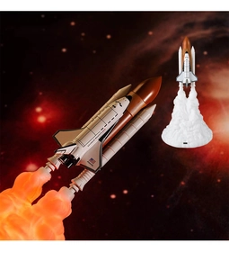Macro shot of 3D printed rocket lamp showing glowing orange exhaust plume and space shuttle