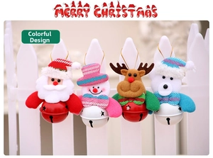 Detail of four Christmas plush ornaments with metal bells on a white picket fence