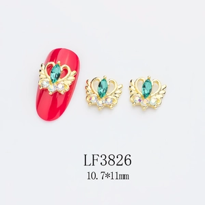 Détail d'un bijou d'ongle cœur vert 10,7x11mm avec ailes d'ange sur un ongle rouge