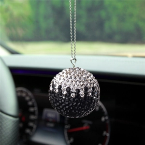 Detail of a crystal-encrusted car rearview mirror charm with black and white gradient ball