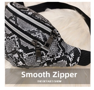 Close-up of grey snakeskin waist bag showing dual metal zippers and scale texture