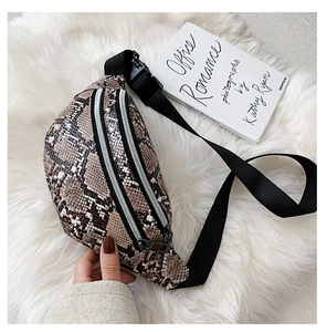 Detail shot of snakeskin print fanny pack with metal zipper on plush white background