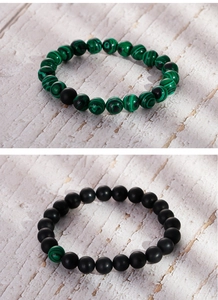 Macro view of matte black agate and green malachite beaded bracelets with elastic cord