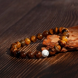 Tiger eye and turquoise beaded bracelet for couples on natural wood and bark background
