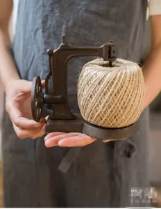 Detail of vintage cast iron sewing machine string holder with natural jute twine