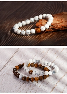 Detail of beaded bracelets with tiger eye and marble stones on a natural wood surface