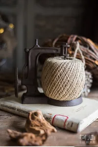 Detail of vintage cast iron twine holder with natural jute rope on antique books