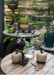 Rustic cast iron jute twine holder with bird and vintage sewing machine decor in a garden
