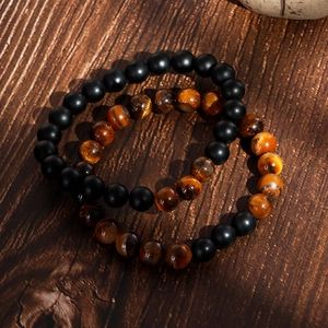 Classic beaded bracelet set with matte black beads and tiger eye stones on wooden surface