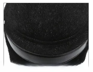 Detailed macro view of black faux fur winter hat crown with reinforced leather stitching