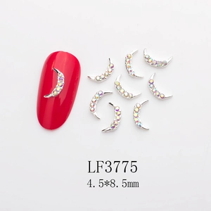 Detailed view of silver moon-shaped nail charms with AB rhinestones for DIY nail art design