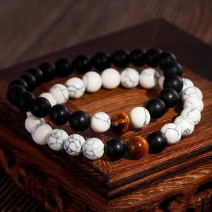 8mm matte schwarze Achat- und weiße Marmorperlen-Armband-Set auf dunklem Holzsockel