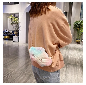 Macro view of fluffy gradient cloud-shaped plush bag with golden chain and embroidery
