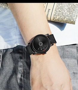 Men's black watch with mesh strap shown in a lifestyle scene worn by a model