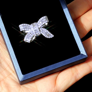 Close-up of luxury bow-shaped ring featuring emerald-cut stones and micropavé diamonds