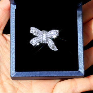Detailed macro view of bow-shaped ring with baguette-cut and round cubic zirconia settings