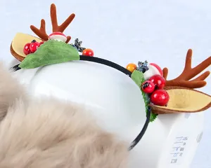 Detailed view of Christmas reindeer antlers headband with faux berries and mushroom decor