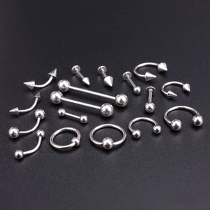 Macro detail of high-polish stainless steel body jewelry set on black surface