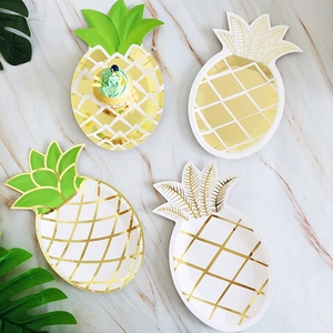 Nahaufnahme von goldenen Ananas-Papptellern auf Marmor-Hintergrund, perfekt für Party-Dekor.