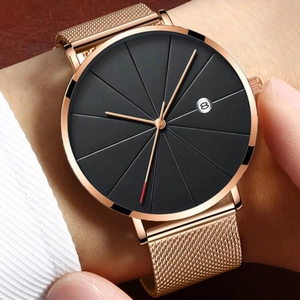 Detail of rose gold mesh watch band and black dial with date window on wrist