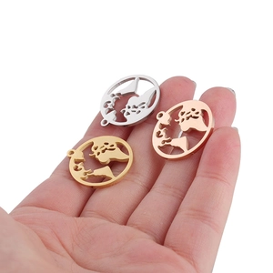 Hollow world map pendant in gold, silver, and rose gold finishes on a palm for scale