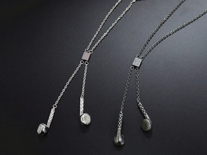 Detailed view of hip hop headphone pendants in silver and gunmetal titanium steel finish