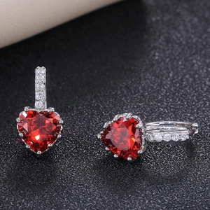 Detailed macro shot of red heart-shaped zircon earrings with silver micro-pave setting