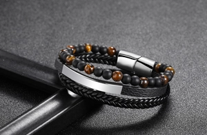 Macro shot of 6mm tiger eye stone beads and multi-layer braided leather bracelet with clasp
