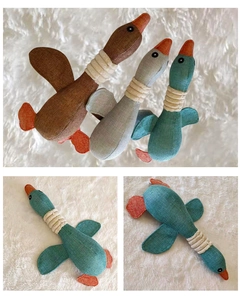 Detail view of durable wild goose plush dog toys in grey, brown, and cyan colors