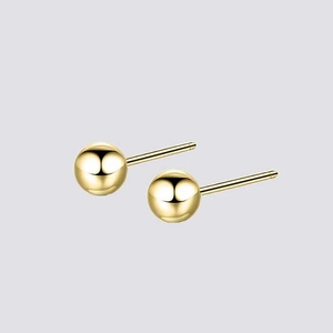 Detailed view of polished gold sphere earrings with high gloss mirror finish